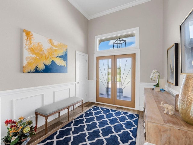 entrance foyer with french doors, crown molding, hardwood / wood-style flooring, and a towering ceiling