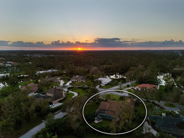 aerial view at dusk featuring a water view