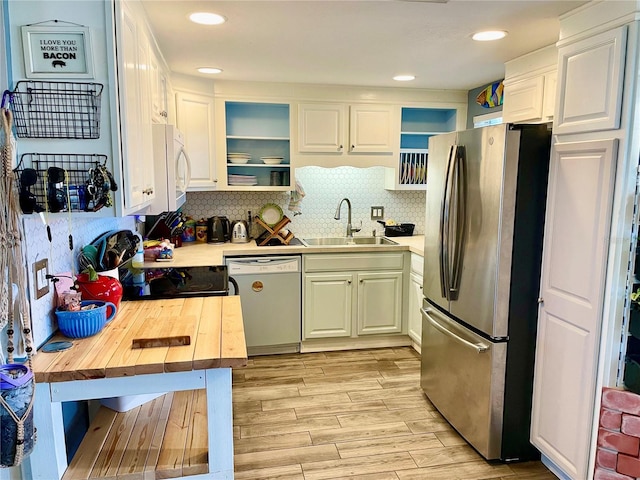 kitchen featuring light hardwood / wood-style flooring, sink, white cabinetry, white appliances, and tasteful backsplash