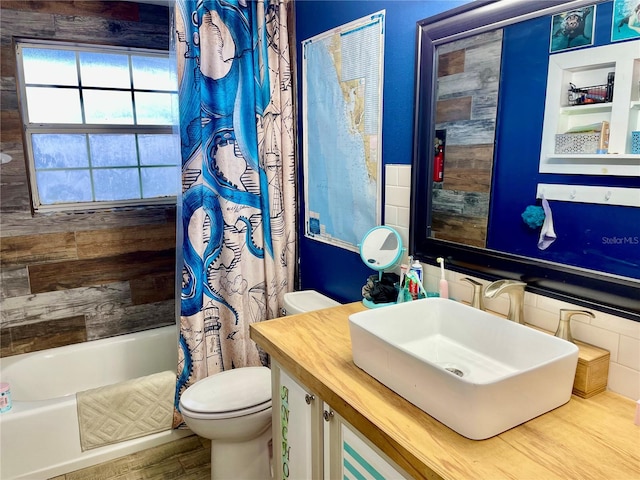 full bathroom featuring vanity, hardwood / wood-style floors, shower / bath combo with shower curtain, and toilet