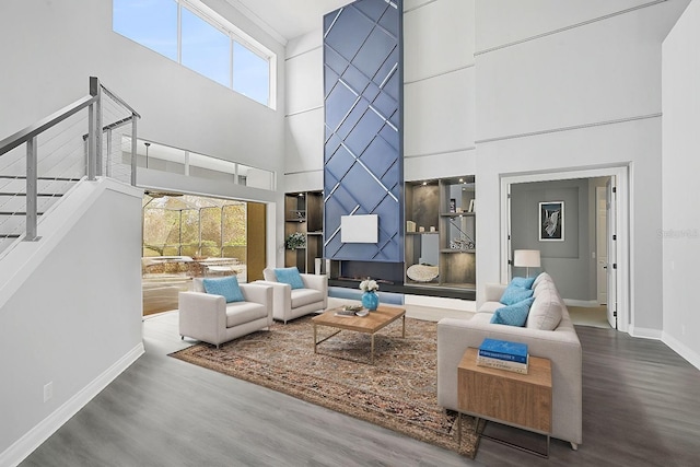 living room featuring hardwood / wood-style floors, a healthy amount of sunlight, and a towering ceiling