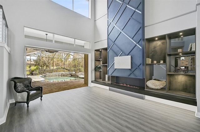 sitting room featuring hardwood / wood-style flooring and a towering ceiling