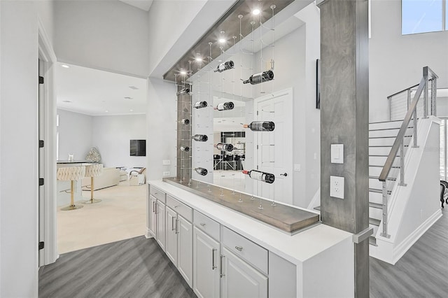 interior space with a high ceiling, vanity, and hardwood / wood-style floors