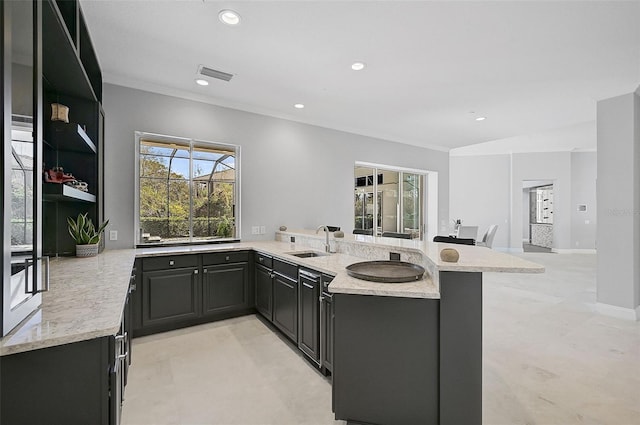 kitchen with kitchen peninsula, sink, and light stone counters