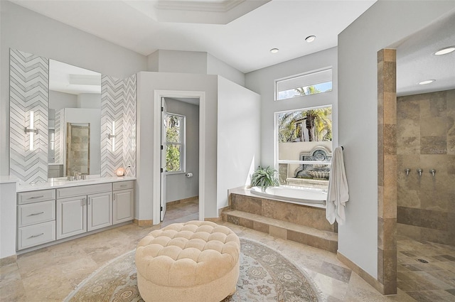 bathroom featuring shower with separate bathtub, a wealth of natural light, and vanity