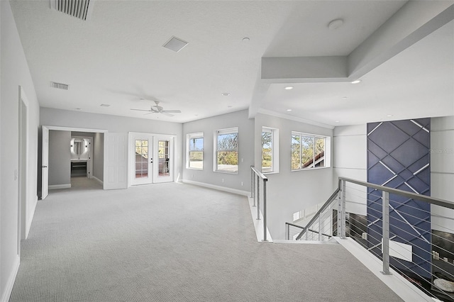 interior space with french doors, light carpet, and beam ceiling