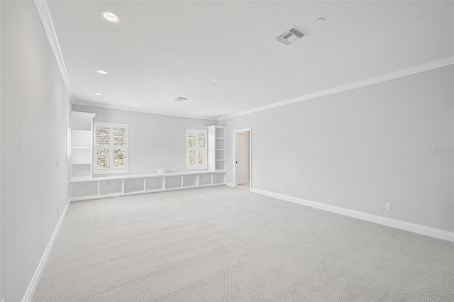 empty room featuring light colored carpet and crown molding