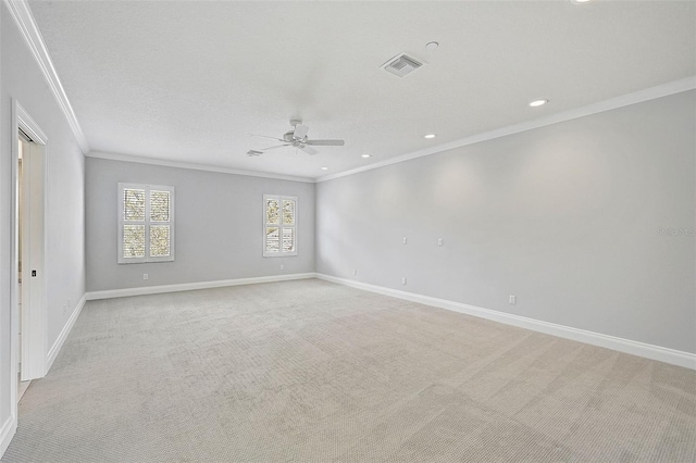 spare room with a textured ceiling, light colored carpet, ceiling fan, and crown molding