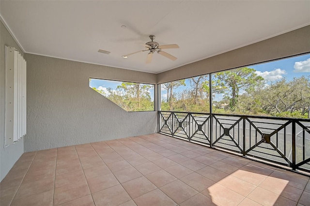 unfurnished sunroom with ceiling fan