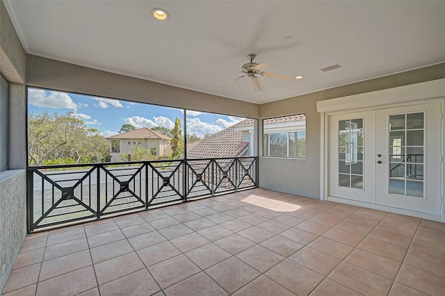 unfurnished sunroom featuring ceiling fan and french doors