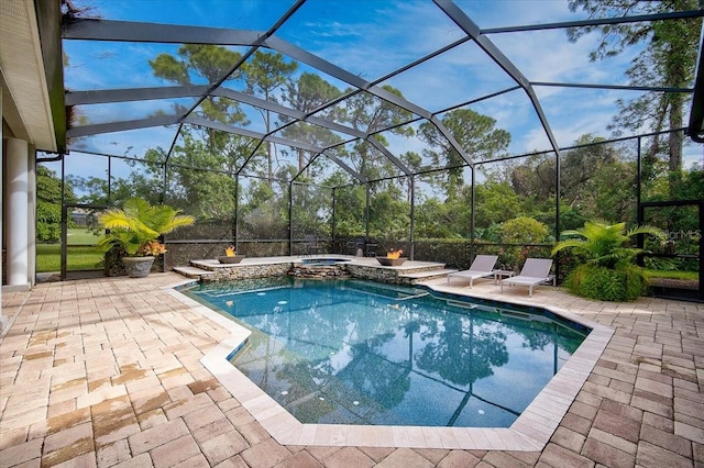 view of pool with a patio, glass enclosure, and an in ground hot tub