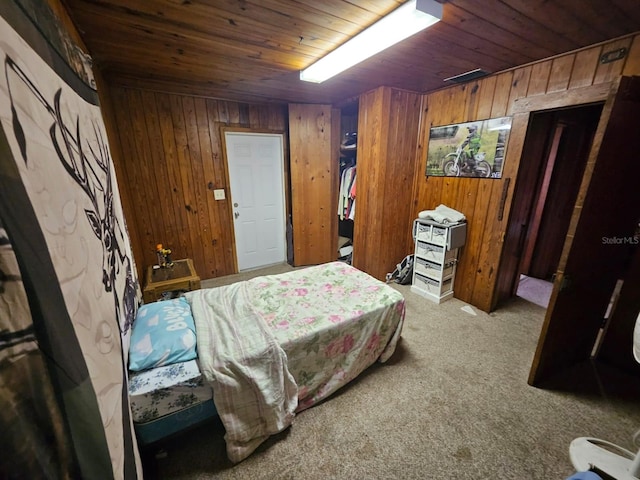 bedroom featuring light carpet, wood ceiling, and wooden walls