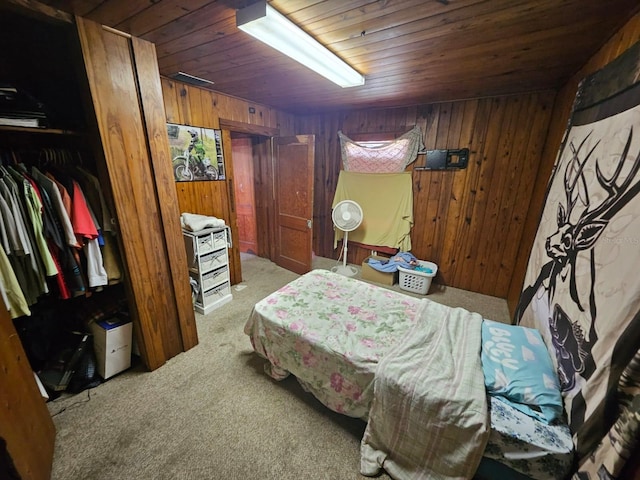 bedroom featuring wooden ceiling, light colored carpet, a closet, and wood walls