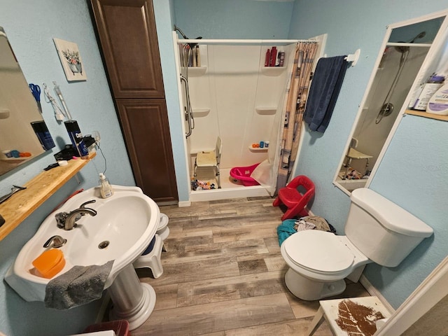 bathroom with toilet, hardwood / wood-style flooring, and a shower with shower curtain