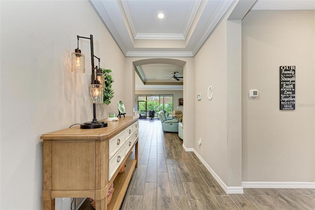 hall featuring crown molding, dark hardwood / wood-style floors, and a raised ceiling