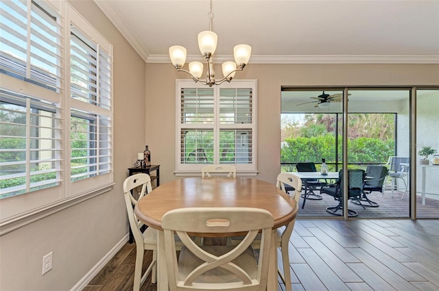 dining space featuring dark wood-type flooring, ornamental molding, a wealth of natural light, and ceiling fan with notable chandelier