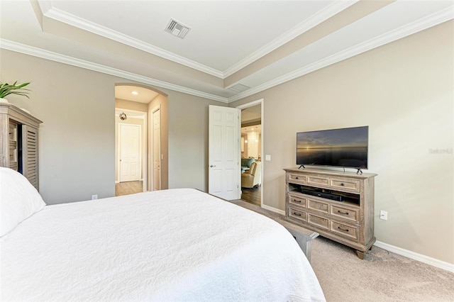 carpeted bedroom featuring crown molding and a raised ceiling