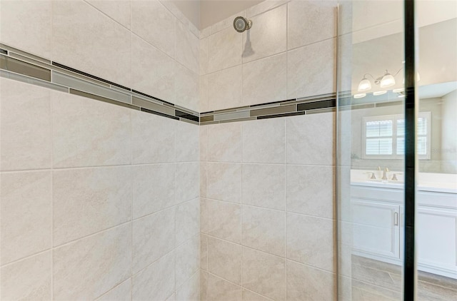 details featuring vanity and tiled shower