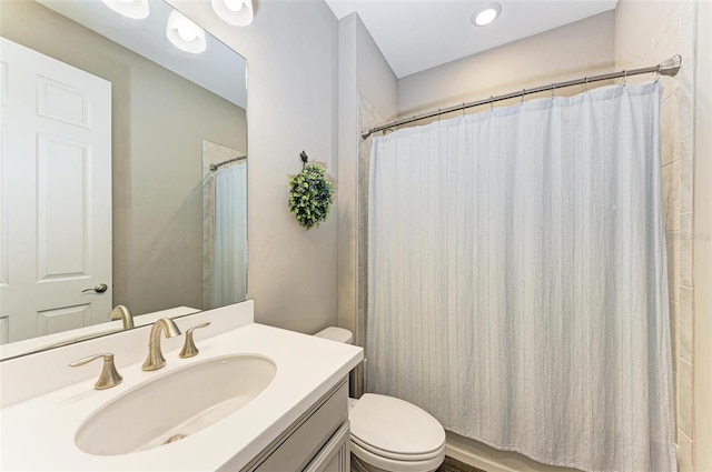 bathroom featuring vanity, toilet, and walk in shower