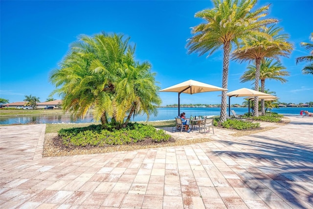 view of community featuring a water view and a patio area