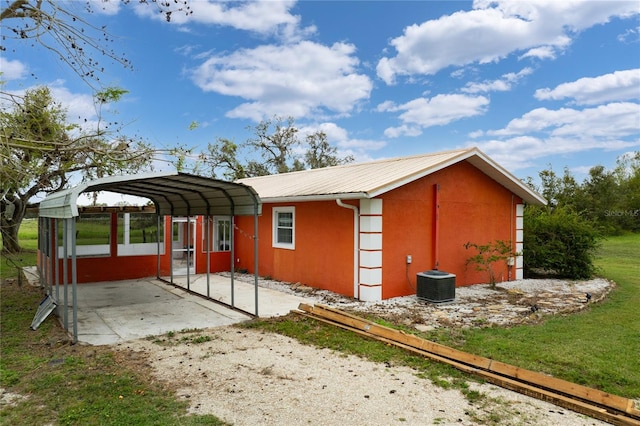 view of property exterior featuring cooling unit, a carport, and a yard