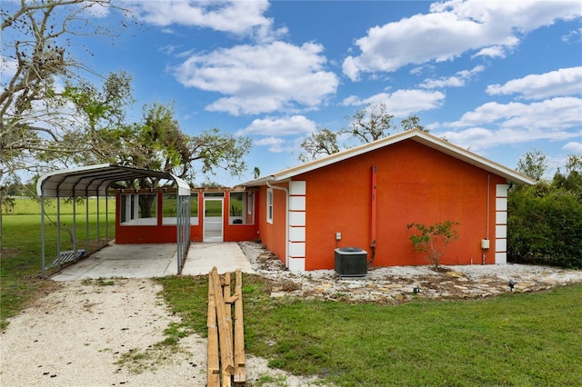 view of home's exterior with central AC, a carport, and a yard