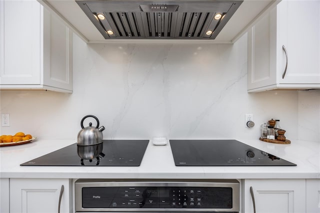 kitchen with black electric cooktop, wall oven, custom exhaust hood, and white cabinets