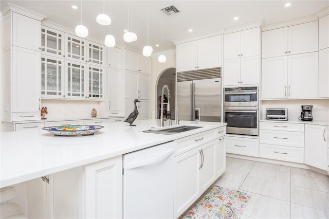 kitchen with white cabinetry, stainless steel appliances, sink, and hanging light fixtures