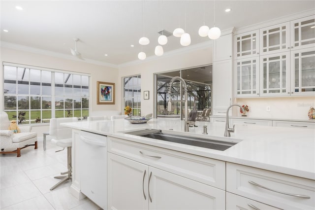 kitchen featuring pendant lighting, sink, light tile patterned floors, dishwasher, and white cabinetry