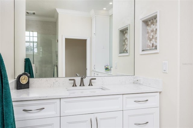 bathroom with vanity, ornamental molding, and a shower with shower door