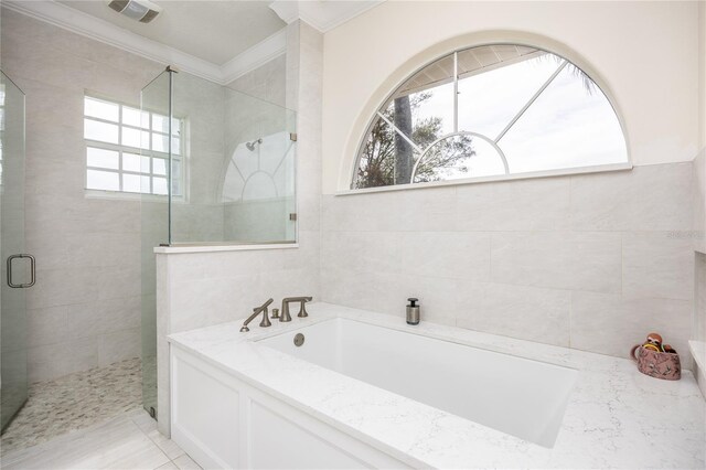 bathroom with tile patterned floors, ornamental molding, and shower with separate bathtub