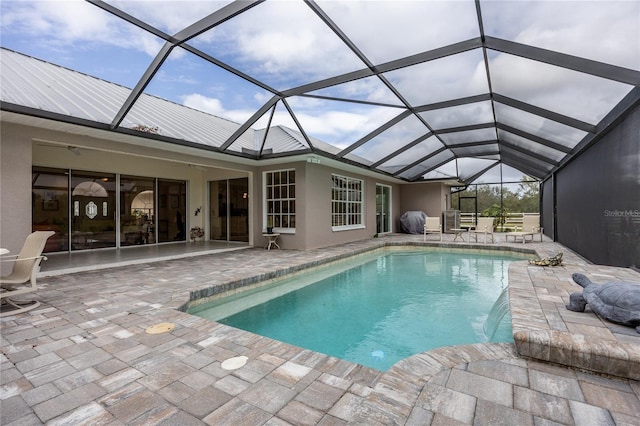 view of pool featuring a lanai, a grill, pool water feature, and a patio area