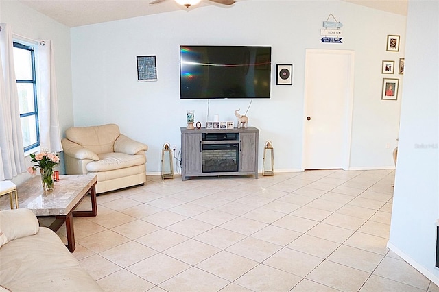 living room featuring vaulted ceiling, light tile patterned floors, and ceiling fan