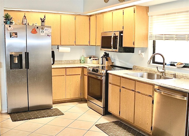 kitchen featuring light brown cabinetry, appliances with stainless steel finishes, sink, and light tile patterned floors