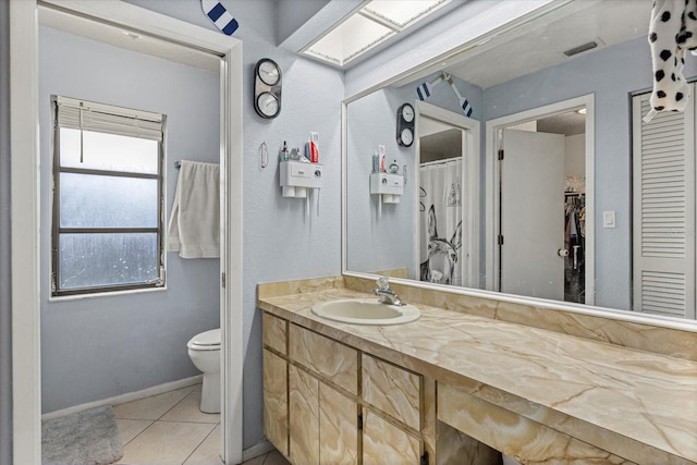 full bathroom featuring a closet, visible vents, toilet, vanity, and tile patterned floors