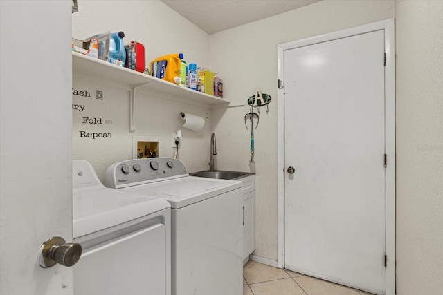 washroom featuring a sink, cabinet space, washer and dryer, and light tile patterned flooring