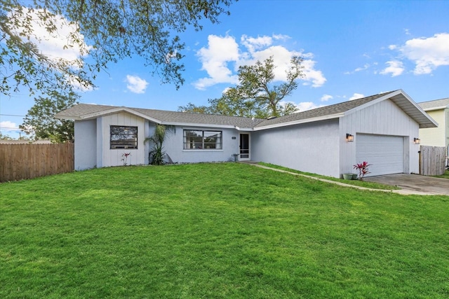 view of front of home featuring an attached garage, concrete driveway, a front yard, and fence