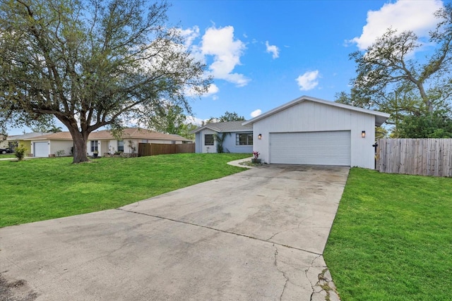 single story home with an attached garage, fence, concrete driveway, and a front yard