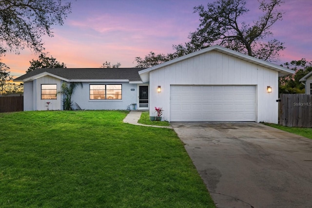 ranch-style house with concrete driveway, roof with shingles, an attached garage, fence, and a front yard