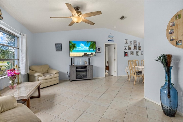 living room with light tile patterned floors, ceiling fan, visible vents, and vaulted ceiling