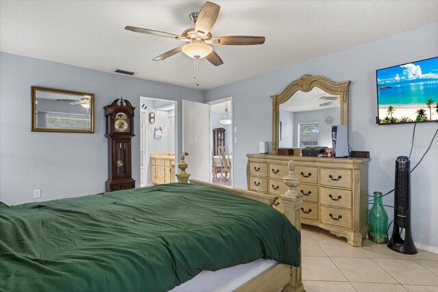 bedroom with light tile patterned flooring, ensuite bath, visible vents, and a ceiling fan