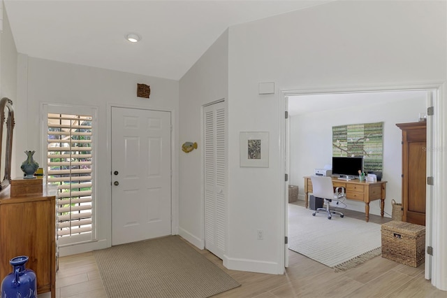 entryway featuring light hardwood / wood-style floors and vaulted ceiling