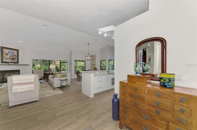 interior space with lofted ceiling, sink, a notable chandelier, and light hardwood / wood-style floors