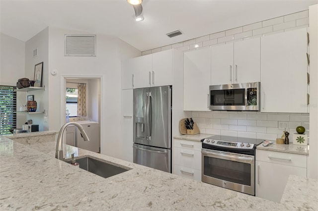 kitchen featuring white cabinetry, light stone counters, appliances with stainless steel finishes, and sink