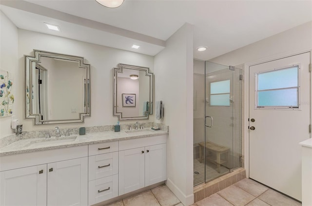 bathroom featuring vanity, a shower with shower door, and tile patterned flooring