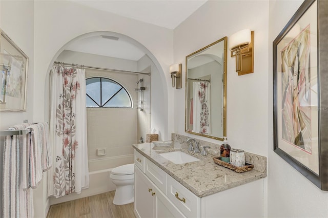 full bathroom with vanity, shower / bath combo, hardwood / wood-style flooring, and toilet