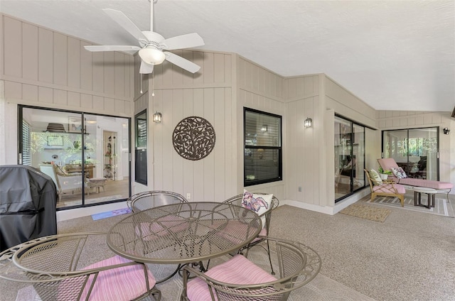 dining area with carpet, ceiling fan, a textured ceiling, and lofted ceiling