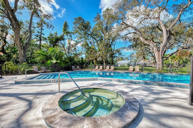 view of pool with a hot tub and a patio