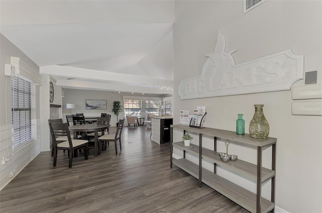 dining area featuring dark hardwood / wood-style floors and high vaulted ceiling