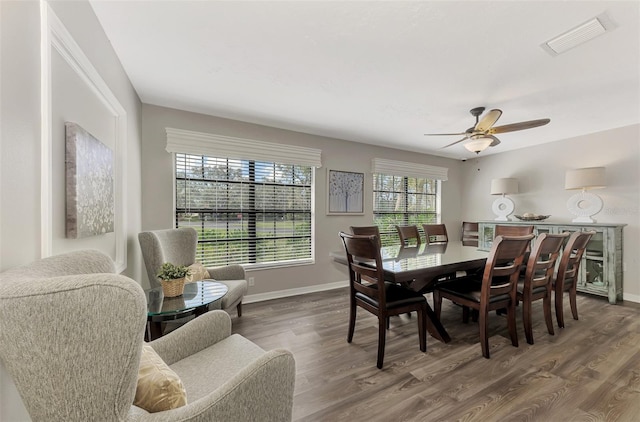 dining space with dark wood-type flooring and ceiling fan